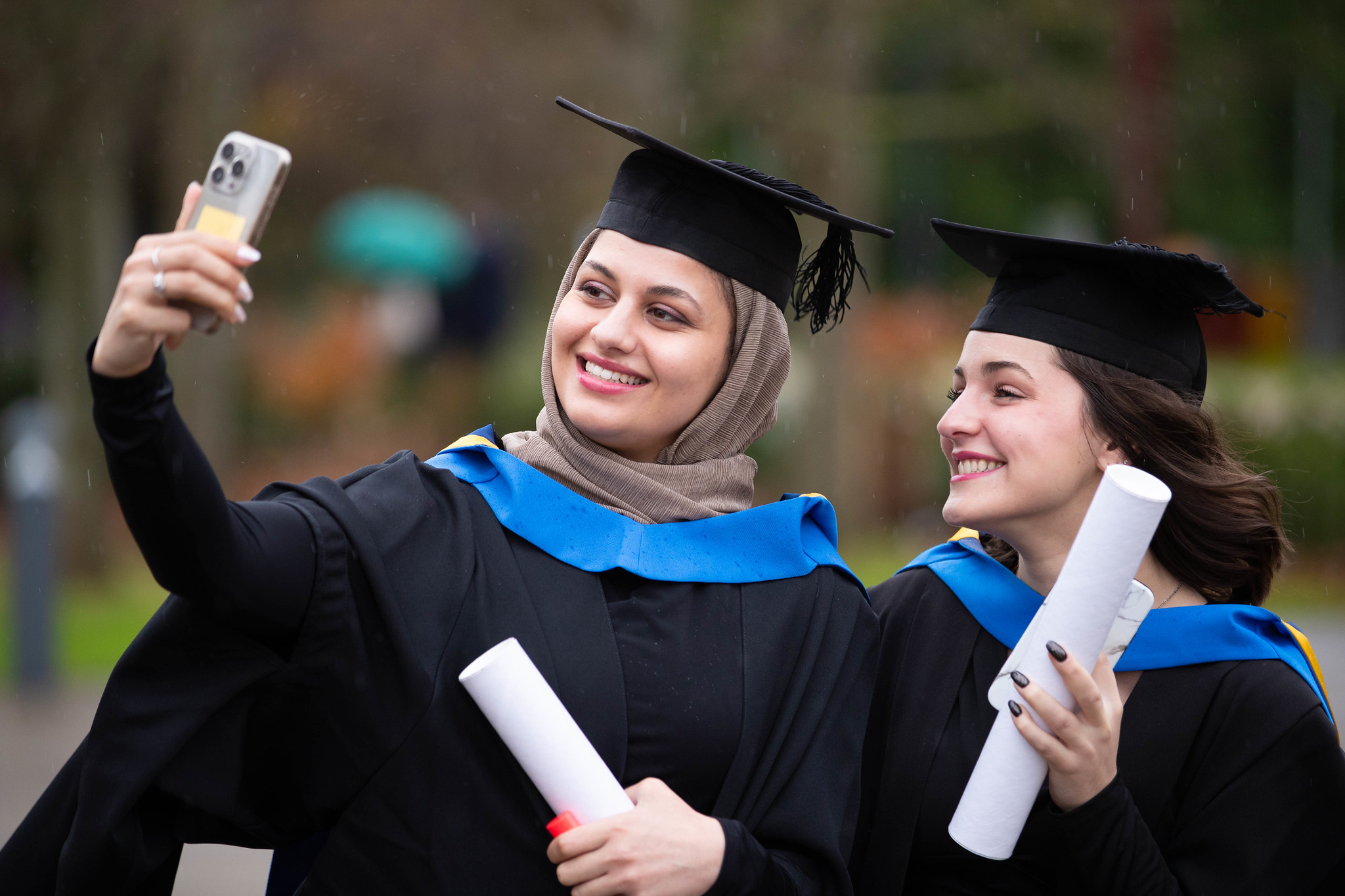 2 students taking a selfie with scrolls